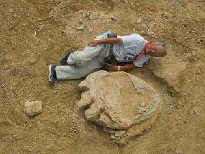 Okayama University of Science Professor Shinobu Ishigaki poses next to a dinosaur footprint in the Gobi Desert 
