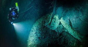 In this underwater photo taken Aug. 15, 2015 in the flooded Hranicka Propast, or Hranice Abyss, in the Czech Republic is seen Polish explorer Krzysztof Starnawski exploring the limestone abyss and preparing for deeper exploration with the use of a remotely-operated underwater robot, or ROV. On Sept. 27, 2016, the robot went to the record depth of 404 meters (1,325 feet) revealing the abyss to be the world's deepest flooded cave, during the 'Hranicka Propast - step beyond 400m' expedition led by Starnawski and partly funded by the National Geographic. Credit: Krzysztof Starnawski of EXPEDITION via AP