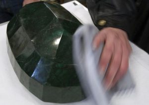 A worker polishes the world's largest emerald at Western Star Auction House in Kelowna, British Columbia January 26, 2012. The 57,500 carat emerald, named "Teodora", which weighs 11.5 kg (25.35 lb) was mined in Brazil and cut in India. The stone will be publicly auctioned this weekend. REUTERS/Andy Clark 