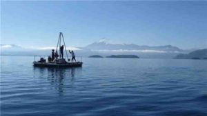Researchers taking sediment cores on Chilean lake Calafquén (with Villarrica Volcano in the background).