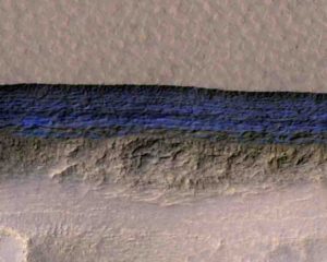 A cross-section of underground ice is exposed at the steep slope that appears bright blue in this enhanced-color view from the HiRISE camera on NASA's Mars Reconnaissance Orbiter. 