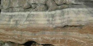 Field photograph of massive flowstone layers from one of the South African hominin caves, with red cave sediments underneath.