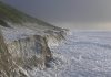 Luminous grains of sand determine year of historic storm flood
