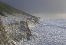 Luminous grains of sand determine year of historic storm flood