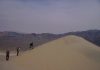Physics of booming and burping sand dunes revealed