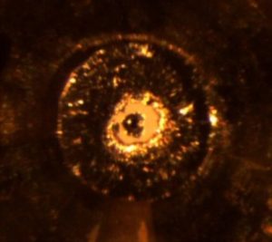 An international team working at the Advanced Photon Source at Argonne National Laboratory has devised a method for achieving static pressures vastly higher than any previously reached. Above: an image of a diamond anvil cell inside the pressure chamber. Traditionally, a diamond anvil cell works like a vice that squeezes the sample between two single-crystal diamonds to produce extreme pressure. In the new device, a miniscule ball of nano-crystalline diamonds sits atop each single-crystal diamond. As the diamonds are squeezed together, the load is transferred from the larger diamond to the nano-ball. This causes the nano-diamond balls to compress and actually get harder, allowing them to both generate and withstand extreme pressures. Credit: Image via Dubrovinskaia et al./Science