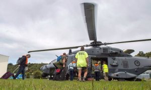 People walking to a helicopter with their suitcases as hundreds of tourists were evacuated from Kaikoura, after an earthquake hit New Zealand 