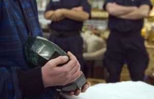 A visitor holds the world's largest emerald as security guards stand nearby at the Western Star Auction House in Kelowna, British Columbia January 26, 2012. The 57,500 carat emerald, named "Teodora", which weighs 11.5 kg (25.35 lb) was mined in Brazil and cut in India. The stone will be publicly auctioned this weekend. REUTERS/Andy ClarkREUTERS/Andy Clark