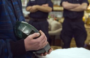 A visitor holds the world's largest emerald as security guards stand nearby at the Western Star Auction House in Kelowna, British Columbia January 26, 2012. The 57,500 carat emerald, named "Teodora", which weighs 11.5 kg (25.35 lb) was mined in Brazil and cut in India. The stone will be publicly auctioned this weekend. REUTERS/Andy ClarkREUTERS/Andy Clark 