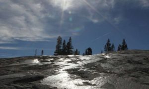 Glacial polish reflects sunlight at Pothole Dome in Yosemite National Park, California.