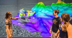 The Galicia group -- from left, Rice graduate student Nur Schuba, alumnus Ara Alexanian and graduate research assistant Mari Tesi Sanjurjo -- discuss the northwest portion of the 3-D seismic volume at Rice's Visualization Lab.