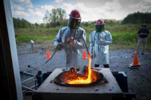 Ingo Sonder, a research scientist at UB's Center for Geohazards Studies, stirs the molten rock as it melts inside the furnace. Credit: Douglas Levere / University at Buffalo