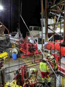 The floormen (in yellow jackets) and drillers (in white booths in background) of Expedition 383 retrieve core barrels and sediment cores around the clock. Credit: Jenny Middleton/Lamont-Doherty Earth Observatory