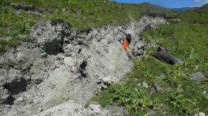 Jesse leaning against the fresh fault scarp of the Kekerengu fault, next to some of the curved slickenlines. Credit: Professor Tim Little