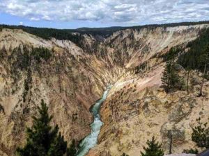 A river flows between mountains at Yellowstone National Park in Wyoming. New research tests a 30-year-old theory on the relationship between erosion and mountain height. Photo credit: Seth Cottle/Unsplash