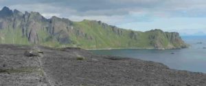 The grey line in the rock, running from the foreground away under the boulder towards the mountains, is one of the shear zones from the study area. Credit: Lucy Campbell