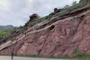 Francis Macdonald walks along a road near Manitou Springs, Colorado, where an exposed outcrop shows a feature known as the "Great Unconformity."