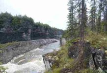 Longest known continuous record of the Paleozoic discovered in Yukon wilderness Ordovician black shales of the Mount Hare Formation, Road River Group (approximately 465 million years old) rise above conglomerates of the Aberdeen Member. The dangerous rapids of Aberdeen Canyon (Nan Zhak Nadhàdlaii), created by the Peel River cutting through the resistant conglomerates, appear at bottom left. (Image credit: Erik Sperling)