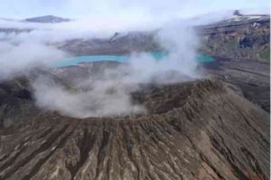 The rim of Cone D—inside the Okmok Volcano caldera—with the blue lake in the background. Credit: Nick Frearson