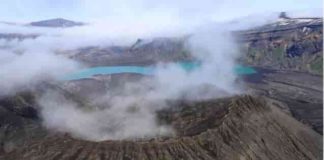 The rim of Cone D—inside the Okmok Volcano caldera—with the blue lake in the background. Credit: Nick Frearson