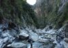 How Water Shapes Mountain Ranges Over Time Roman DiBiase, associate professor of geosciences at Penn State, stands on a boulder in a river channel in central Taiwan. Credit: Provided by Julia Carr . All Rights Reserved.