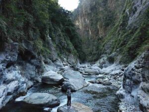 Roman DiBiase, associate professor of geosciences at Penn State, stands on a boulder in a river channel in central Taiwan. Credit: Provided by Julia Carr . All Rights Reserved.