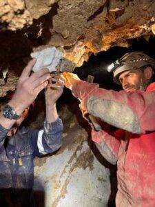 Dominic Stratford of Stony Brook University and Tyler Faith collect a possible hominin tooth found in sediments cemented to the roof of a cave in South Africa’s Cango Valley. The fragile specimen will remain in South Africa and be CT scanned. Credit: Lauren Schroeder, University of Toronto Mississauga