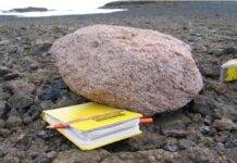 Hidden giant granite discovered beneath West Antarctic Ice Sheet A pink granite boulder next to a yellow notebook for scale. Credit: Jo Johnson, BAS